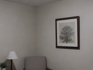 Apartment corner lit only by one cold flush ceiling light with dark lower corners