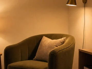 Apartment seating corner with warm pendant, wall sconce, and table lamp at three useful heights