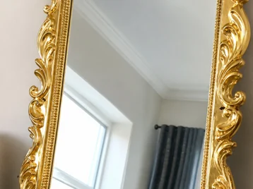 Chunky shiny gold ornate mirror frame surrounded by matching glittery accessories