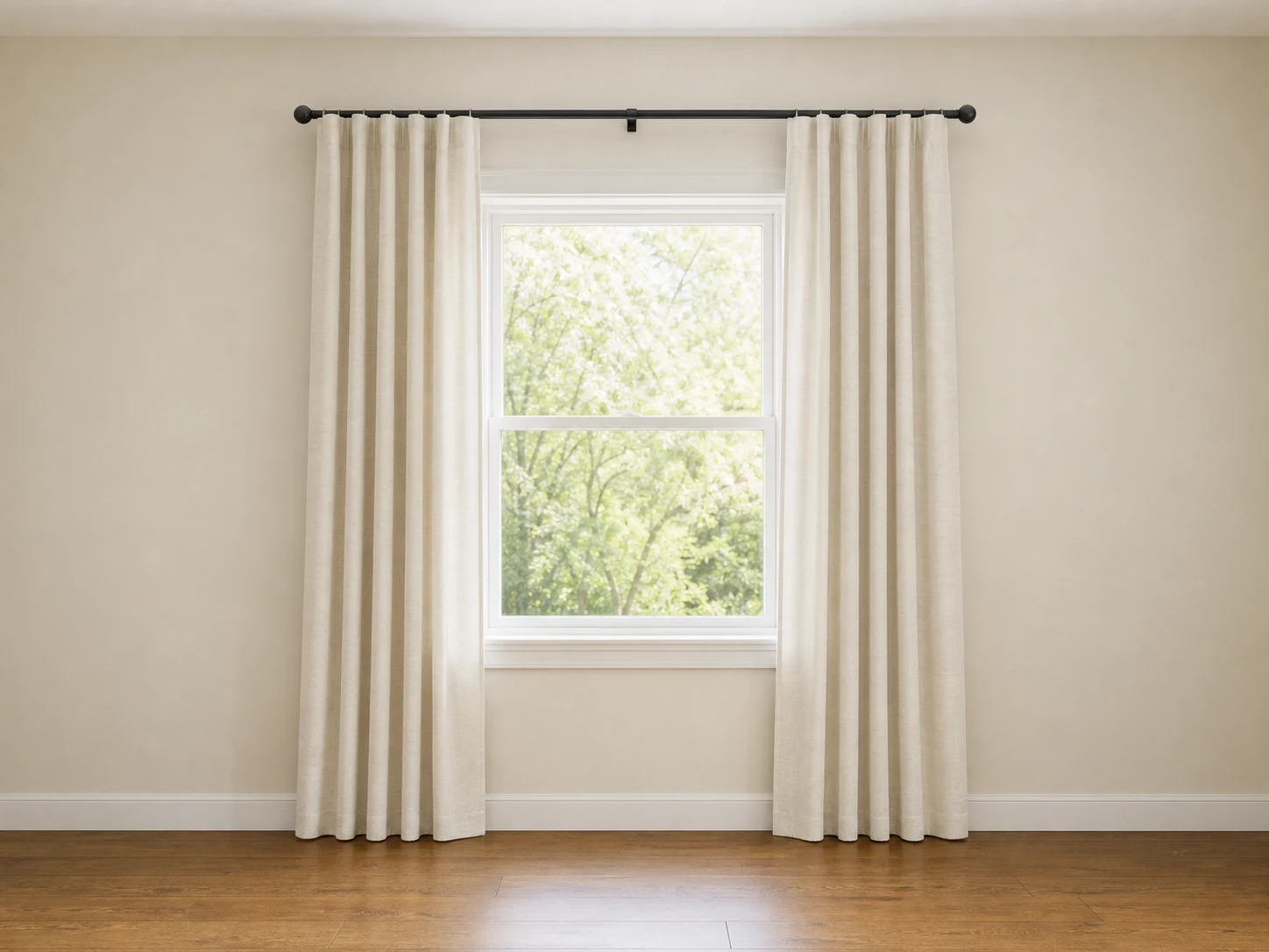 Curtain rod mounted above and wider than a window with floor-length panels stacked beyond the glass