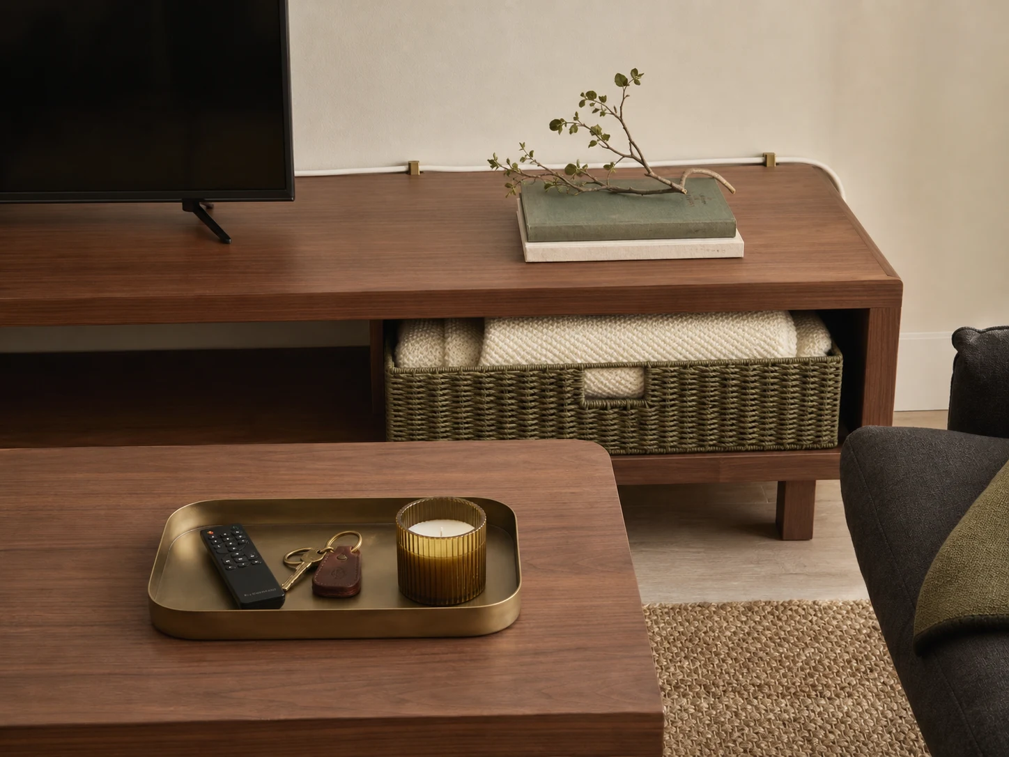 Remote, keys, and candle grouped in tray with blanket contained in basket and cord clipped behind console